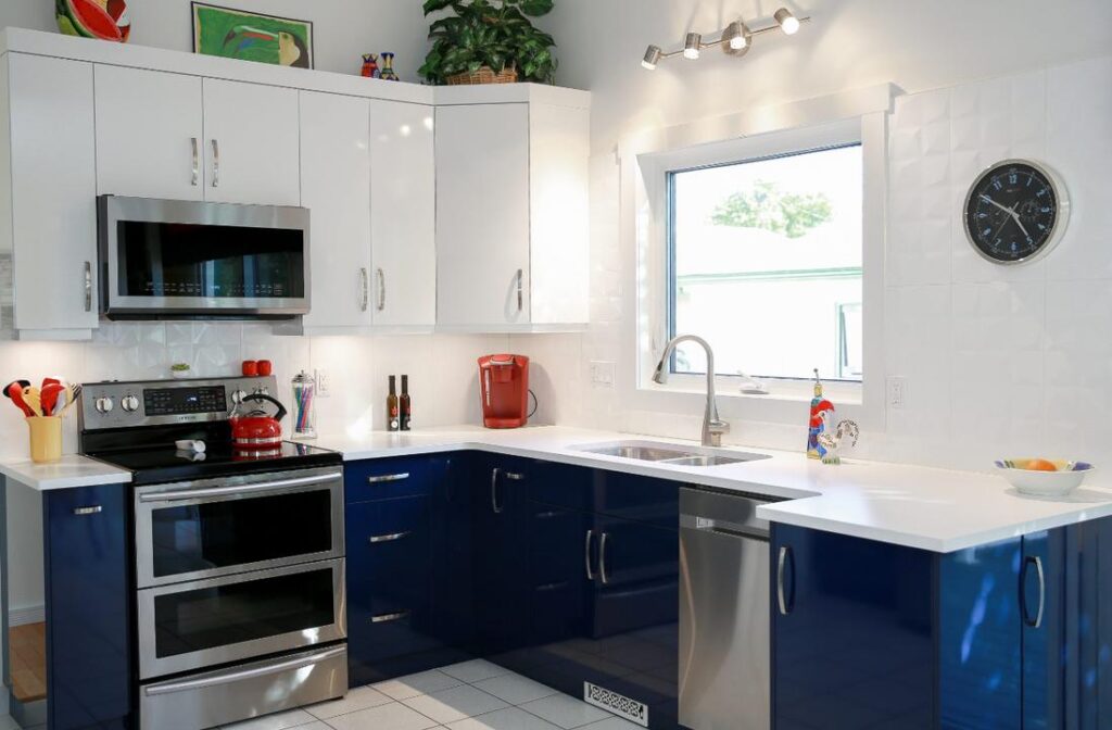 White kitchen with blue cabinets, and white tiled flooring.